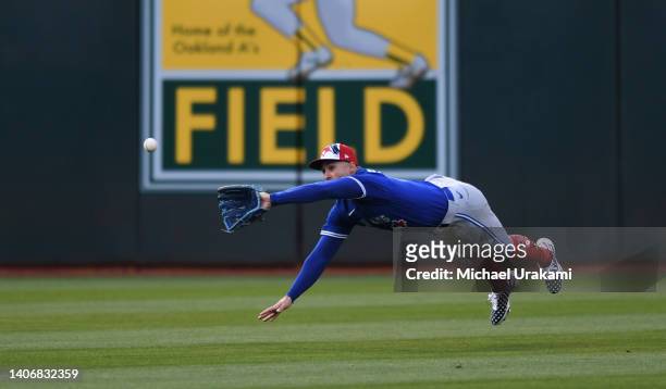 George Springer of the Toronto Blue Jays lays out for a fly ball in the bottom of the seventh inning against the Oakland Athletics at RingCentral...