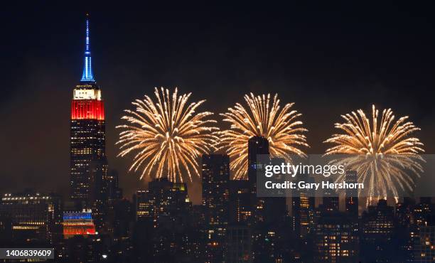 The Macy's 4th of July fireworks show lights up the sky next to the Empire State Building in New York City on July 4 as seen from Union City, New...