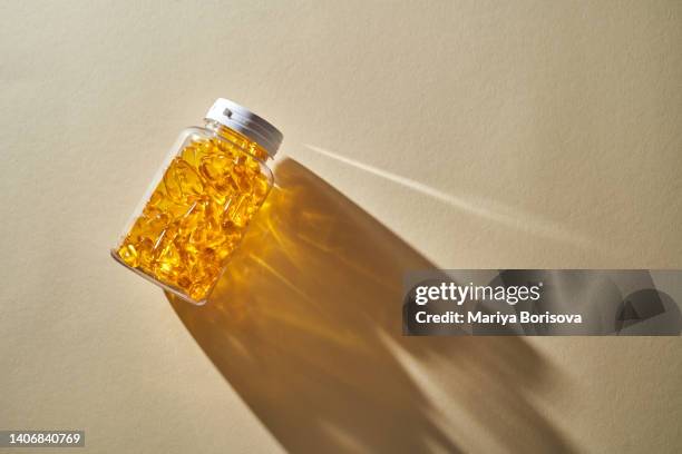 yellow capsules with omega-3 fish oil. - fish oil stock photos et images de collection