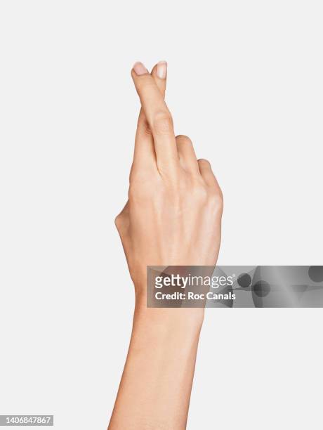 crossing fingers - woman hand crossed stockfoto's en -beelden