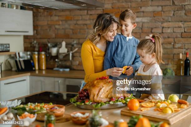 feliz madre soltera y sus hijos decorando pavo de acción de gracias. - thanksgiving fotografías e imágenes de stock