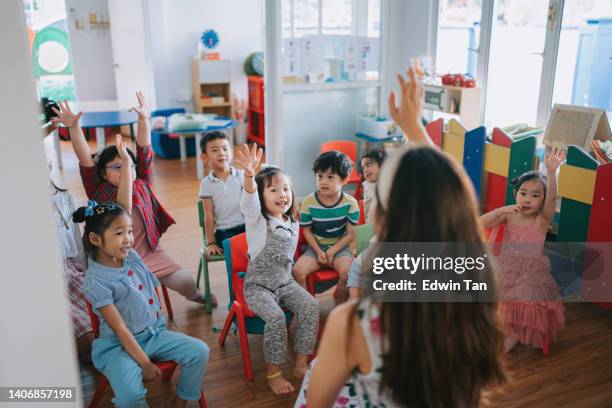 アジアのモンテッソーリ幼稚園児がクラスで手を挙げて質問に答えた - モンテッソーリ教育 ストックフォトと画像