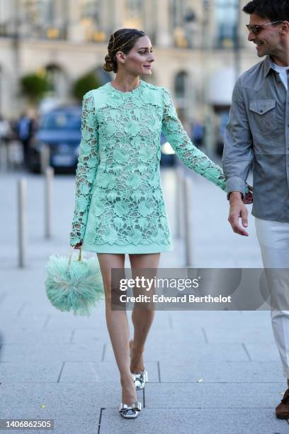 Olivia Palermo wears a pale green / mint green lace print pattern long sleeves short dress, a matching mint green fluffy / feathers handbag, silver...