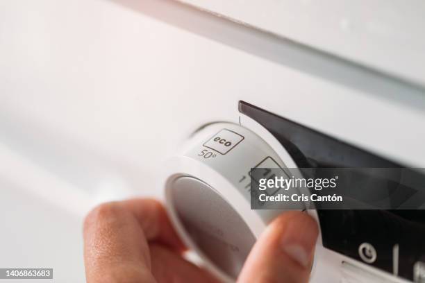 hand setting dishwasher to economy cycle - energy efficient imagens e fotografias de stock