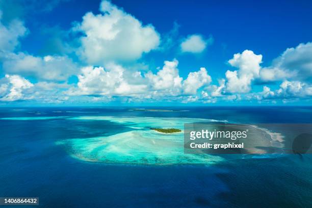 aerial view of tropical island and shallow reef lagoon - indiska oceanen bildbanksfoton och bilder