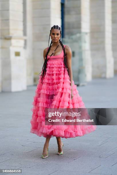 Cindy Bruna wears silver hair rings, a pink square-neck / tank-top / long pleated ruffled long dress, green pearls pointed pumps heels shoes, outside...