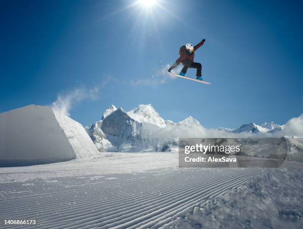 snowboarder-jumping im park - snowboardfahren stock-fotos und bilder
