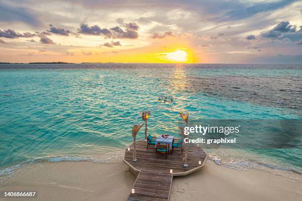 romantisches abendessen am strand mit sonnenuntergangshimmel - maldivas stock-fotos und bilder