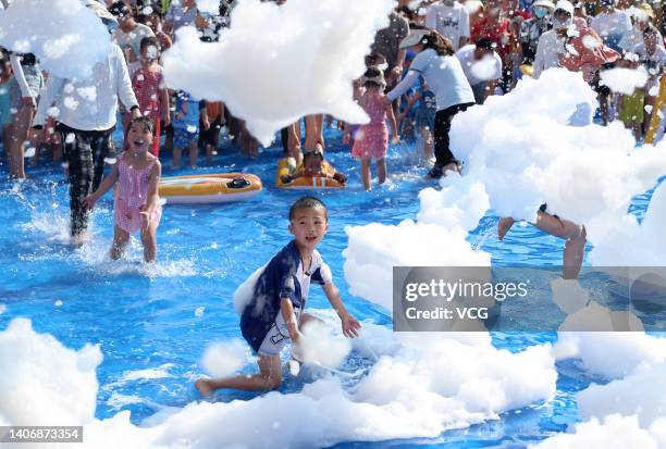 Children and their parents enjoy themselves in a water pool at a kindergarten on a hot summer day on July 5, 2022 in Huaying, Guang an City, Sichuan...