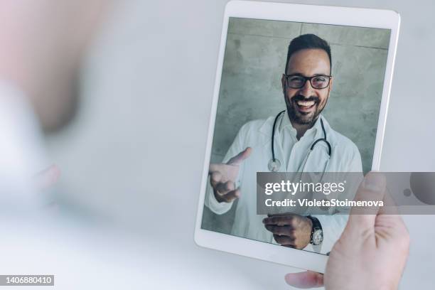 video call with doctor. - over the shoulder view tablet stock pictures, royalty-free photos & images