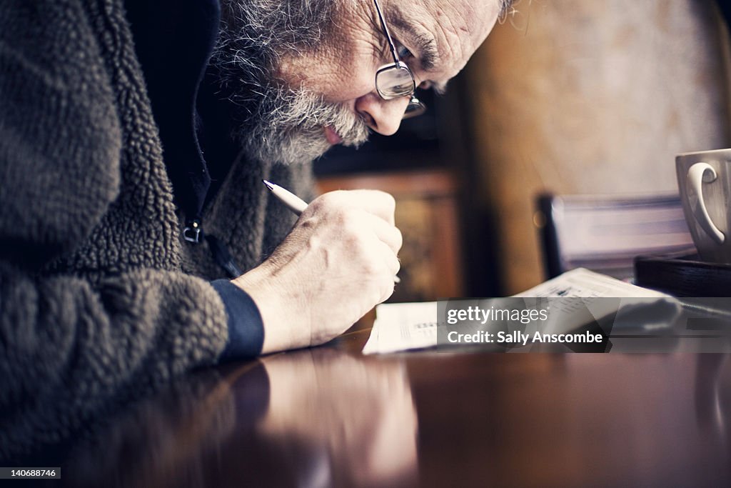 Man Doing Crossword In Newspaper High Res Stock Photo Getty Images Man Doing Crossword In Newspaper High Res Stock Photo Getty Images
