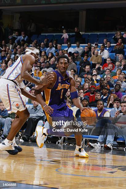 Guard Kobe Bryant of the Los Angeles Lakers dribbles the ball around forward Lamond Murray of the Cleveland Cavaliers during the NBA game at Gund...