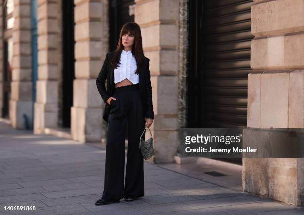 Sabina Jakubowicz seen wearing a white ruffle cropped blouse shirt from Chanel, a black tweed jacket from Chanel, a black wide leg pants, a silver...
