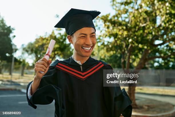 one happy smiling young graduate in gown and hat celebrating success at graduation ceremony. excited and motivated man qualified with diploma or degree achieving academic goals and special milestone - alumni bildbanksfoton och bilder