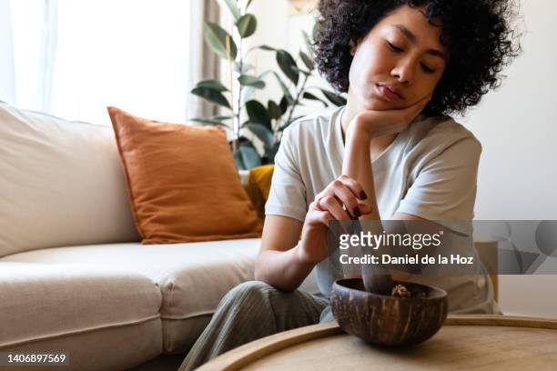 young multiracial woman eating breakfast feeling very bored and unmotivated. lack of appetite. copy space. - bored imagens e fotografias de stock