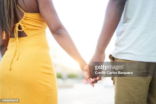 close-up photo of unrecognizable black couple holding hands. - couple close up not smiling stock pictures, royalty-free photos & images