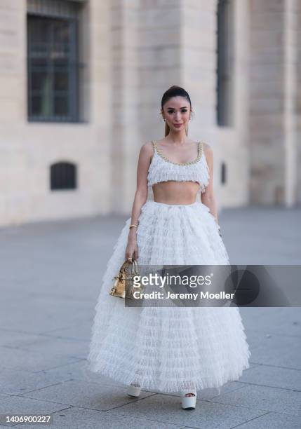 Heart Evangelista seen wearing gold earrings, a white lace print pattern cropped top with embroidered gold borders, a white lace high waist print...