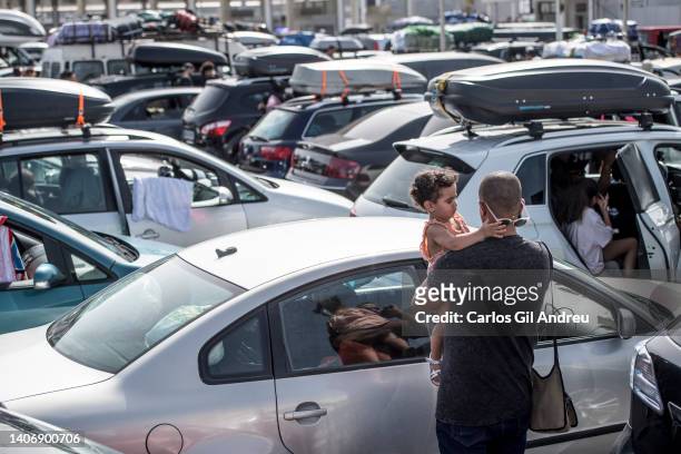 Father holding his daughter wait outside his car in the port of Algeciras waiting to board the ferry to Morocco on July 05, 2022 in Algeciras, Spain....
