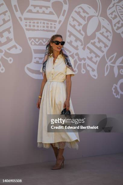 Beatrice Borromeo wears black sunglasses from Dior, a pale purple and black print pattern silk scarf in the hair, a white latte flower print pattern...