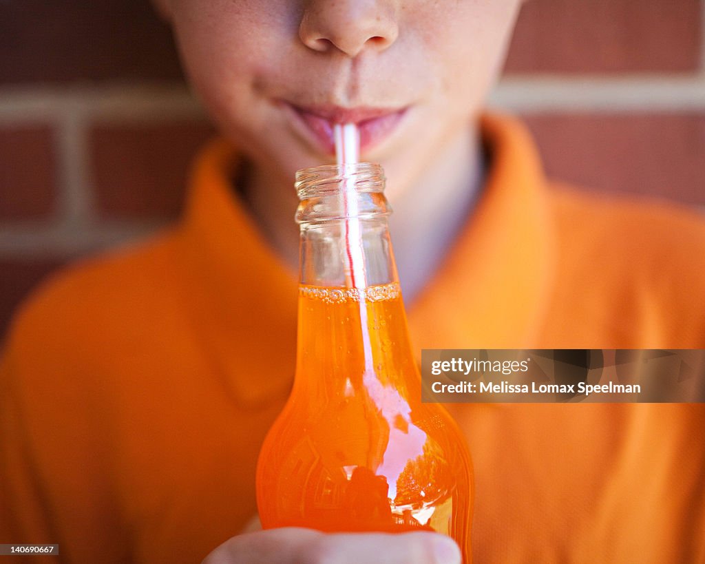 Boy drinking orange soda