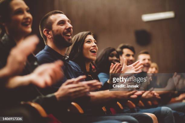 gente feliz aplaudiendo en el teatro - aclamar fotografías e imágenes de stock