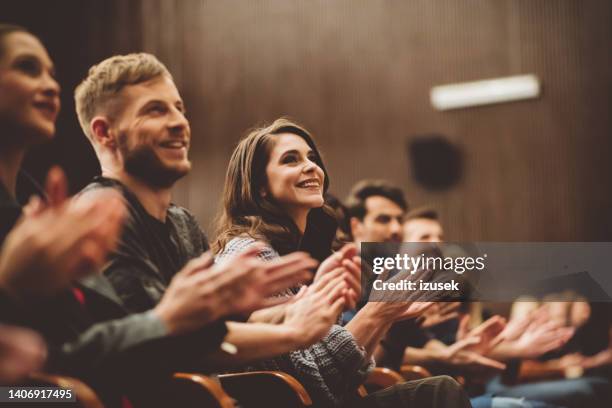 glückliche menschen applaudieren im theater - applaudieren stock-fotos und bilder