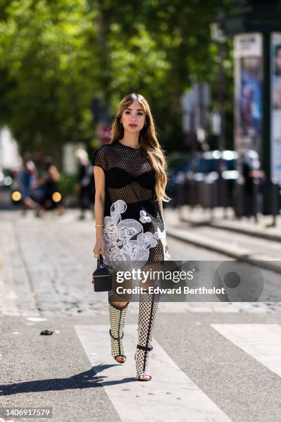 Heart Evangelista wears a black bra underwear, a black fishnet dress with embroidered white flower pattern short sleeves / short dress, black cyclist...