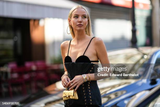 Leonie Hanne wears gold long earrings, a black bra underwear, a black laces corset dress, diamonds bracelets, a gold Juste Un Clou bracelet from...