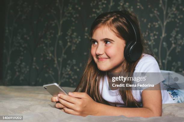 girl in headphones and with a smartphone. - bedroom radio bildbanksfoton och bilder