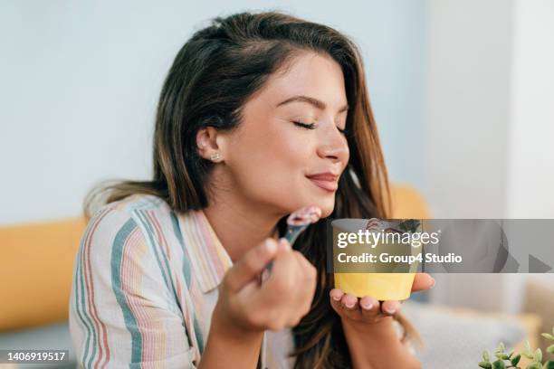 glückliche junge frau genießt in gerolltem eis - gefrorener joghurt stock-fotos und bilder