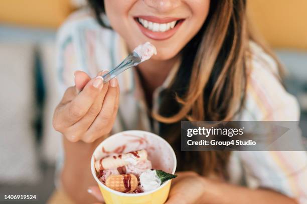 glückliche junge frau genießt in gerolltem eis - gefrorener joghurt stock-fotos und bilder
