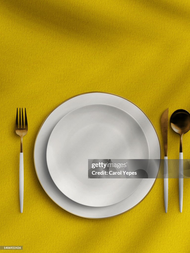 Empty plate table setting iwith fork and spoon in wooden table.Flat lay