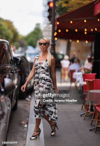 Denisa Palsha seen wearing black sunglasses from Burberry, a white pattern midi dress from Ferrari, a silver leather belt, a silver clutch bag and...