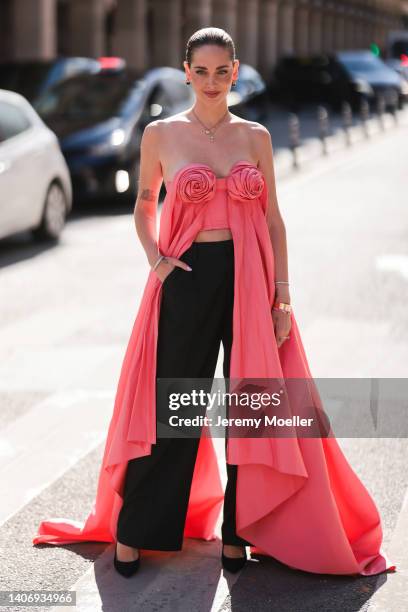 Chiara Ferragni seen wearing gold pendant necklaces, a pink shiny satin off-shoulder flower satin top, black suit pants, black suede pointed pumps...