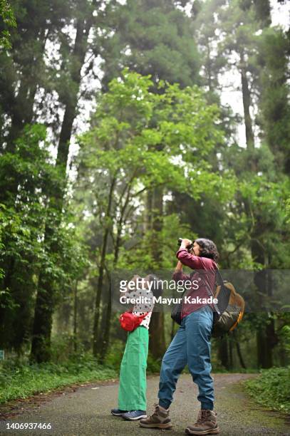 mother and daughter observing through binoculars in a  park - asian child with binoculars stockfoto's en -beelden
