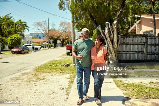 black seniors walking and talking in miami neighborhood - dichterbij komen stockfoto's en -beelden