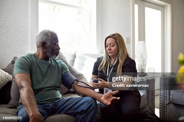 hombre negro mayor que se somete a un chequeo de salud de rutina en casa - residential care fotografías e imágenes de stock