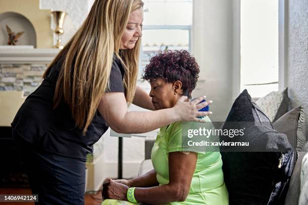 home caregiver and senior woman during massage session - massage ball stock pictures, royalty-free photos & images