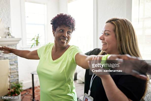 schwarzer senior trainiert mit gesundheitspersonal - residential care stock-fotos und bilder
