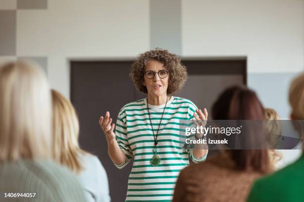 woman sharing experience during seminar - cheftrainer stockfoto's en -beelden