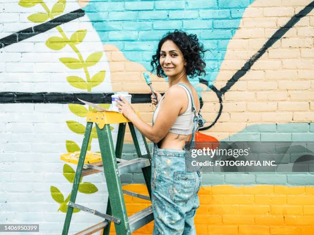 künstlerin malt großes wandbild - wandmalerei stock-fotos und bilder