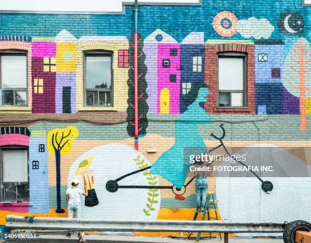 female artist painting large wall mural - street art 個照片及圖片檔