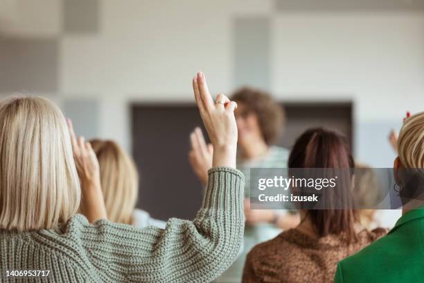 women voting during seminar - democracy uk stock pictures, royalty-free photos & images