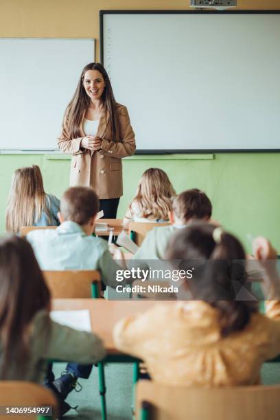lehrerin, die studenten während der vorlesung im klassenzimmer unterrichtet - classroom-front-view stock-fotos und bilder