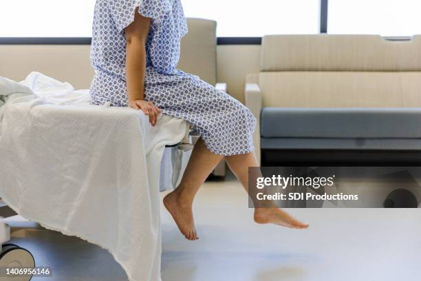 paciente irreconocible con bata de hospital espera los resultados de las pruebas - hospital gown fotografías e imágenes de stock