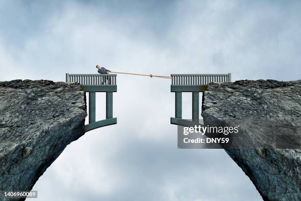 man using rope to bridge the gap - brug stockfoto's en -beelden