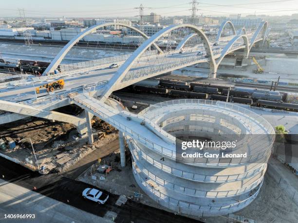 Late afternoon light illuminates the helix structure and the bridge with its arches as it crosses the train yard and LA River during the construction...