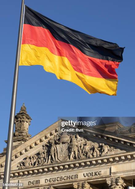 inscription on the west portal of the reichstag building in berlin: "dem deutschen volke" with german flag - deutschland flagge stock-fotos und bilder