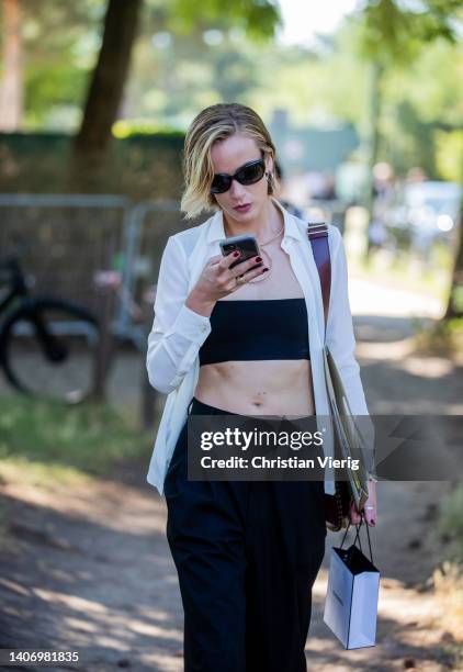 Guest is seen wearing white button shirt, black cropped top, pants outside Chanel Paris Fashion Week - Haute Couture Fall Winter 2022 2023 : Day Two...