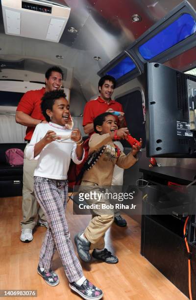 Children play the game 'Wii Party' against Nintendo representatives Curtis Farrell and Russ Levinson at The Grove, December 14, 2010 in Los Angeles,...